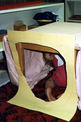 Christina (2 1/2) crawling through the KONOS-style model ear she and Will made in our Montessori classroom, 1992.